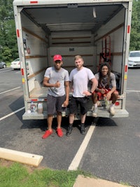 four men standing in the back of a moving truck